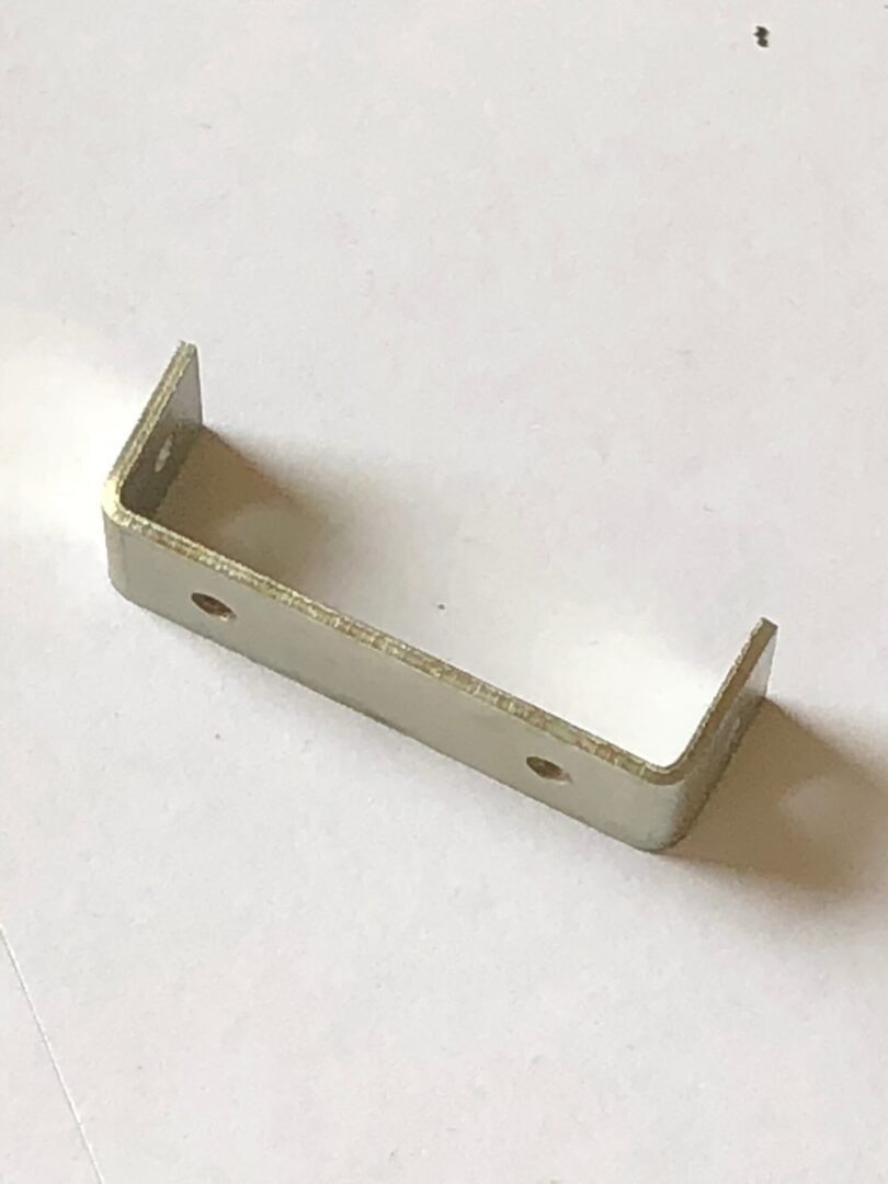A small piece of metal on a white surface.