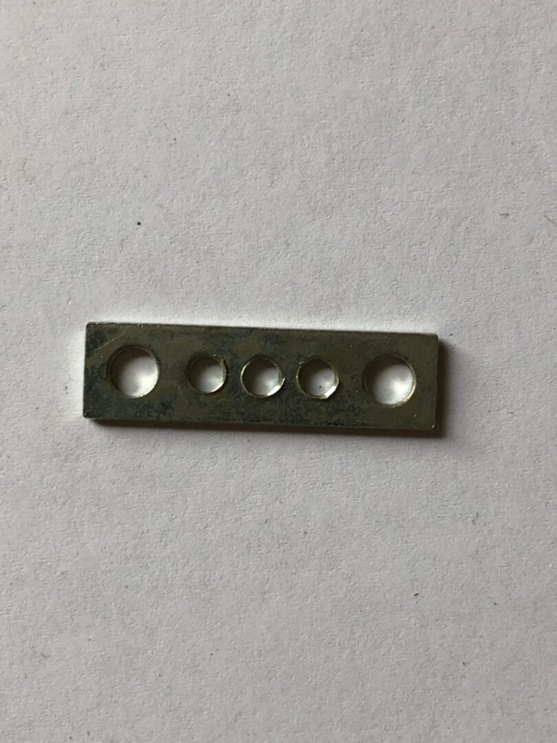 A metal object with four holes on it.