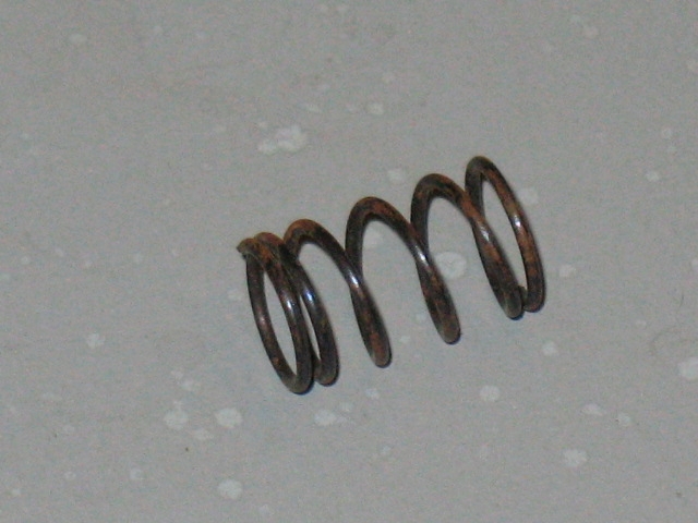 A 125-0011 Trigger spring on a white surface.