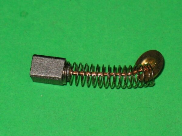 A small 601-5929 Motor brush on a green surface.