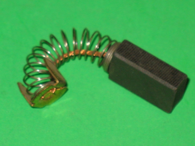 A small 601-6150 Motor Brush on a green surface.