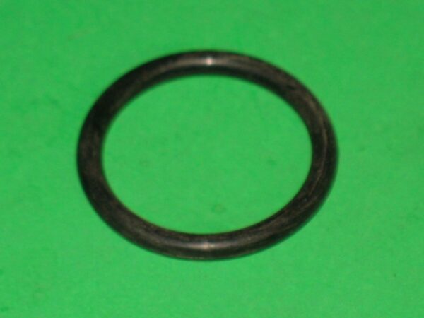 A black round metal object on a green surface.