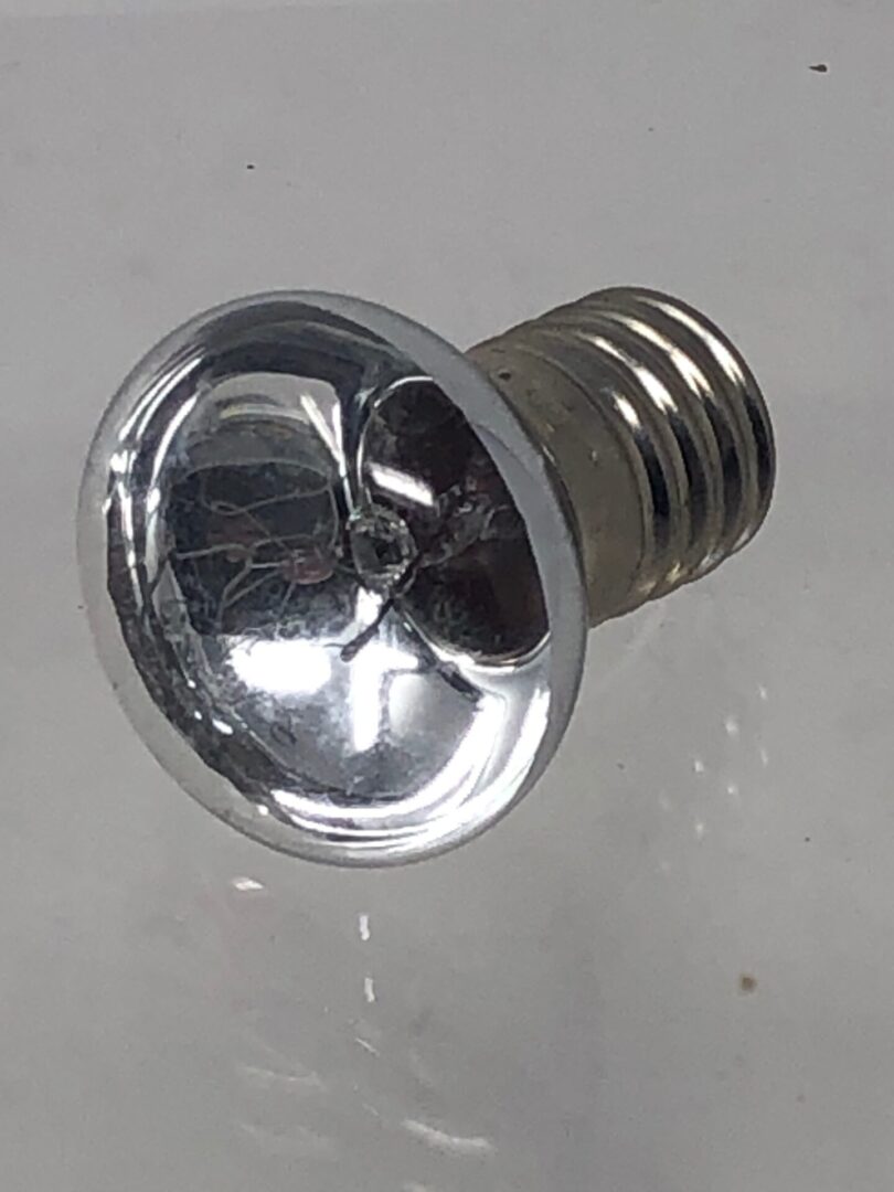 A silver Lamp on a white surface.