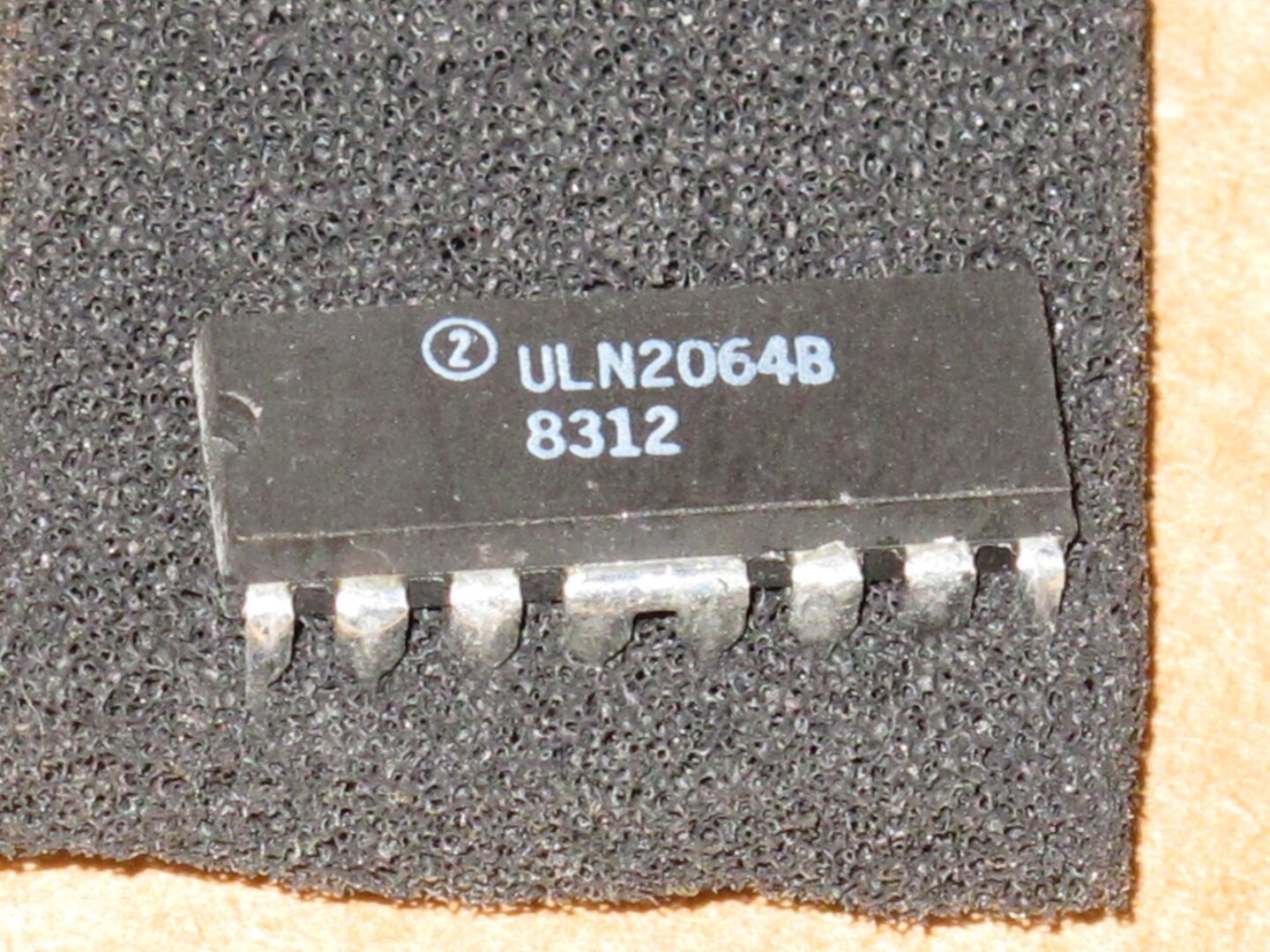 A small ULN2064B IC on a piece of cloth.