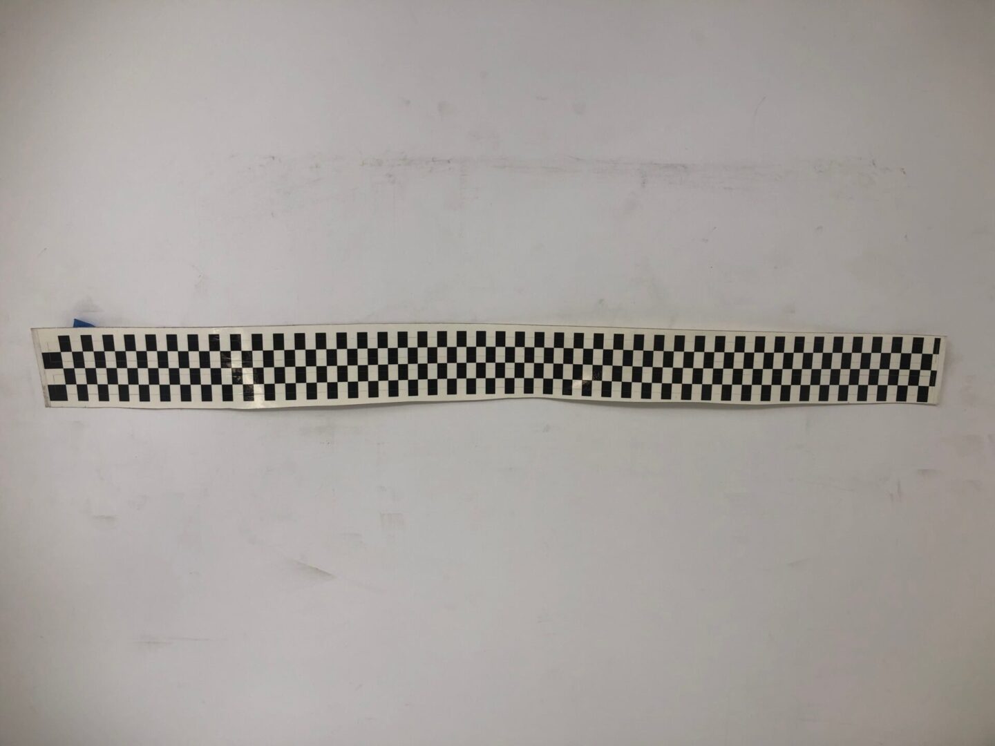 A black and white checkered pattern on a white surface decal.