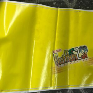 A yellow plastic bag with a black Decal, Front Right Side, Out Run 2 SP logo on it.
