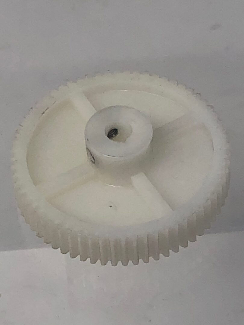 A white plastic Gear 64 on a white surface.