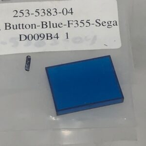 A Blue F355 button is in a package with a piece of plastic.