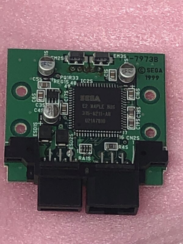 A small NOS Sega LM Converter Board on a pink background.