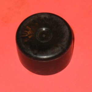 A black Tube Cap on a red surface.