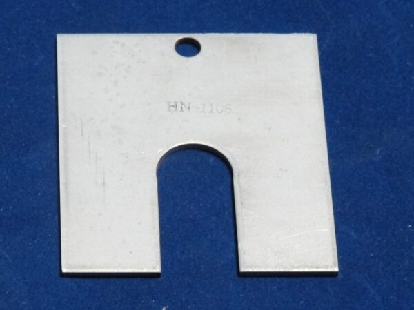 A metal adjust plate with a hole in it.