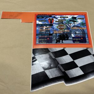 A checkered flag and a racing-themed sticker on a brown surface.