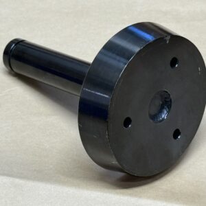 Black plastic cylindrical object with a flat circular top and three holes.